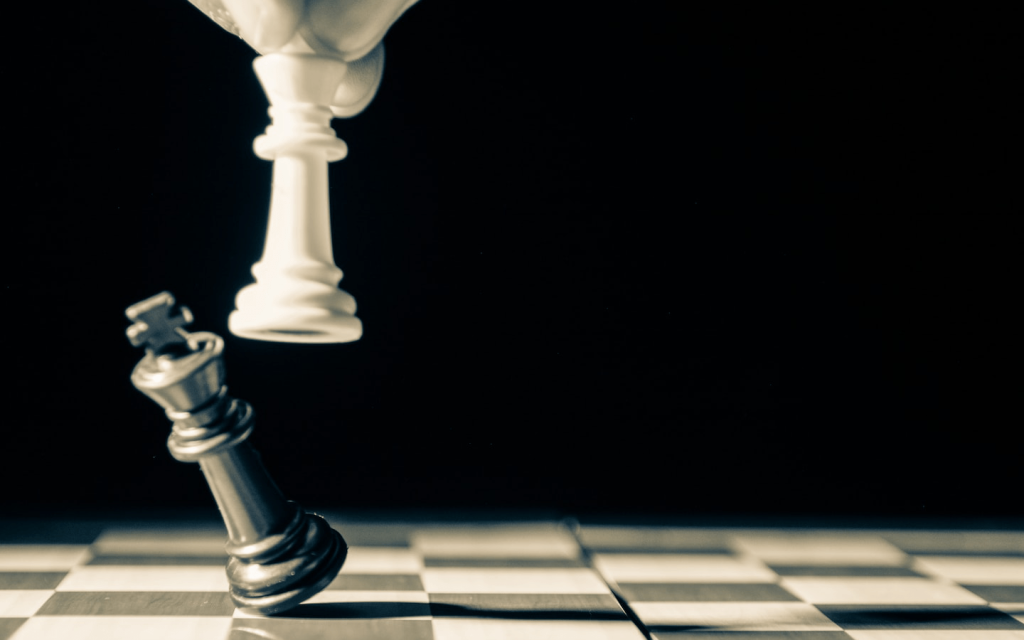 This is a white and black image of white gloved finger tips in the midst of knocking a dark chess piece down on a chess board. This is used to represent Cheoljong's embolden change in episodes 13 and 14 of "Mr. Queen".